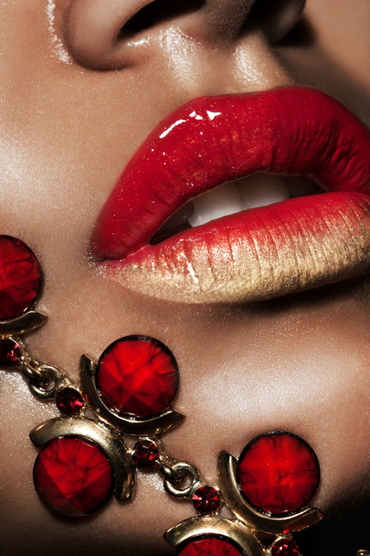 female lips with golden jewelry - Foto, imagen