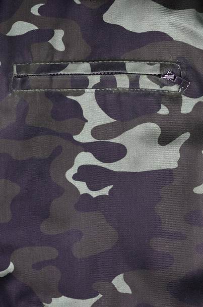 Textura de tela con un camuflaje pintado en colores del pantano con bolsillo. Imagen de fondo del ejército. Patrón textil de tela de camuflaje militar
 - Foto, imagen