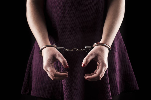 submissive woman wearing a purple dress in metal handcuffs on bl - Foto, Imagen