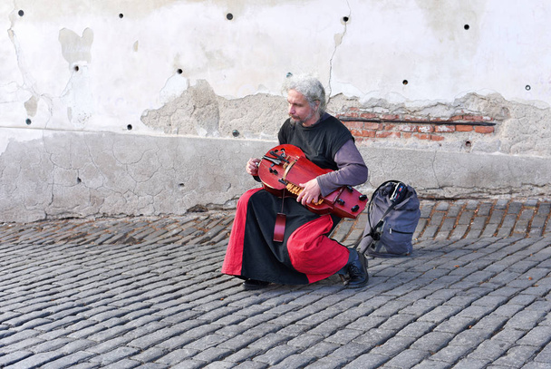 ПРАГА, ЧЕШСКАЯ РЕСПУБЛИКА 1 мая 2017 года: Уличный музыкант играет на старом музыкальном инструменте на городской улице. Хурди-гурди
. - Фото, изображение