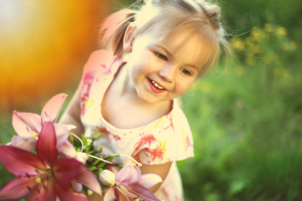 Hermosa chica blanca con una sonrisa y un ramo de flores, tonificado
  - Foto, imagen