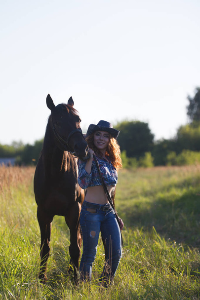 Young attractive woman and horse in the meadow at summer evening - Foto, Imagem