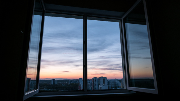 Nuvens de pôr do sol através de uma janela com um reflexo no invólucro da janela
 - Foto, Imagem