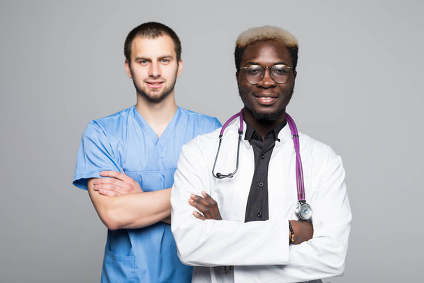 Portrait of doctor and surgeon men standing with arms folded isolated on gray background - Foto, afbeelding