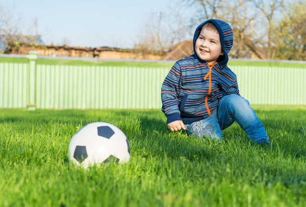Młody chłopak układanie na zielonej trawie - Zdjęcie, obraz