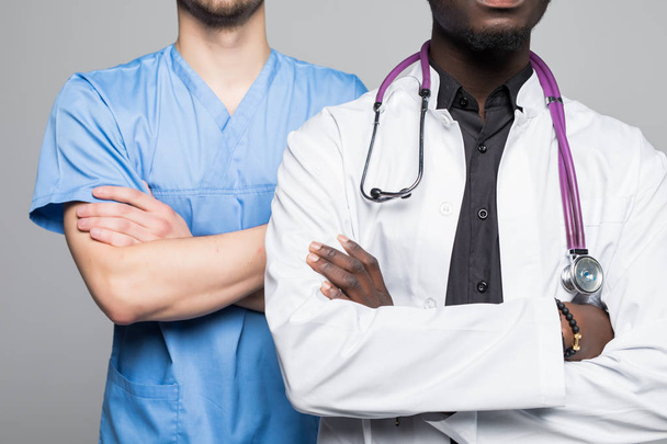Portrait of doctor and surgeon men standing with arms folded isolated on gray background - Foto, afbeelding