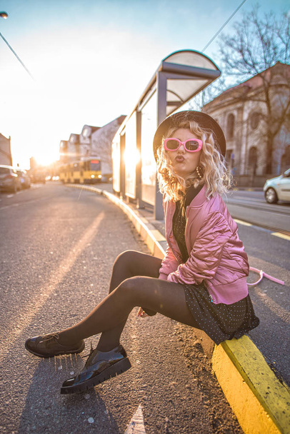 Trendy and stylish woman posing at sunset, street style - 写真・画像