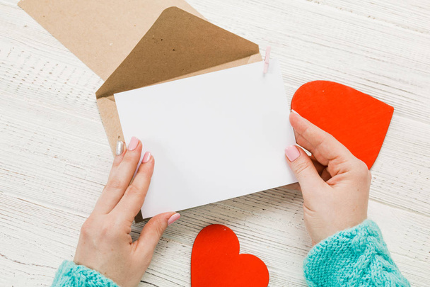 Dłoń dziewczyny pisać list miłosny na Saint Walentynki. Pocztówka z postacią czerwonych w kształcie serca. 14 lutego świąteczny. Koncepcja dzień Valentine z miejsca kopii. - Zdjęcie, obraz