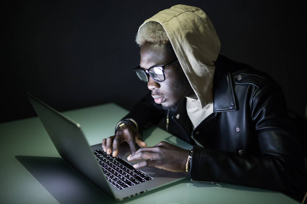 technologie, internet, communicatie en mensen concept - jongeman in glazen met laptopcomputer spelen bij nacht - Foto, afbeelding