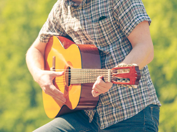 Young man camping playing guitar outdoor - Fotó, kép