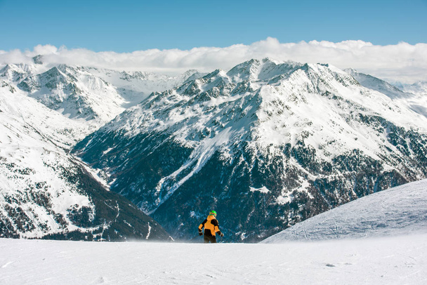 Горный пейзаж и человек. Лыжник начинает спуск с горы
 - Фото, изображение