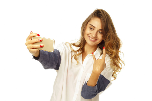 Portrait of a beautiful young woman making selfie on smart phone - Fotó, kép