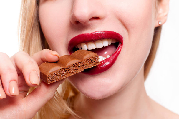 Lovely smiling teenage girl eating chocolate - Photo, Image