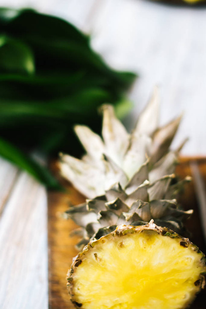 Sliced fresh pineapple on a wooden background in sunlight - Fotoğraf, Görsel