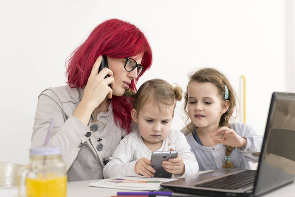 Werk-vanuit-huis moeder praten aan de telefoon met kinderen spelen met S - Foto, afbeelding