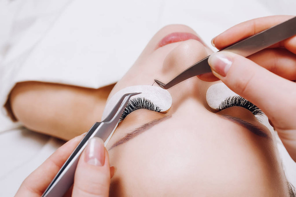 Eyelash Extension Procedure. Woman Eye with Long Eyelashes. Close up, selective focus. - Φωτογραφία, εικόνα
