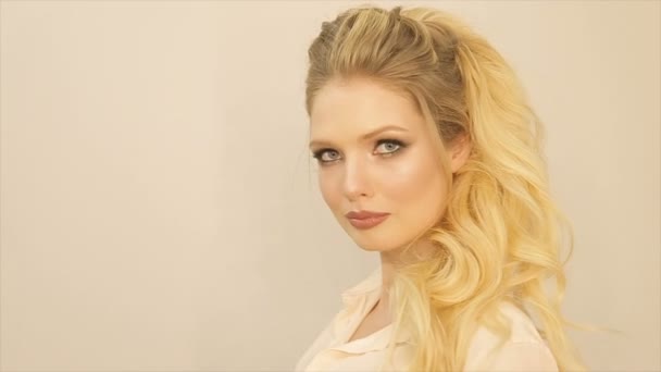 Dolgun dudaklar ve uzun sarı saçları olan bir kız portresi - Video, Çekim