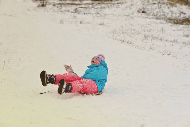Cute young boy smiling while he is sledding - Photo, Image