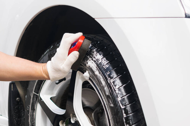 man brushing car wheels, rubber cleaning - Foto, Imagen