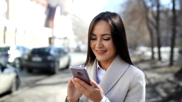 Όμορφη γυναίκα χρησιμοποιώντας το smartphone σε εξωτερικούς χώρους - Πλάνα, βίντεο