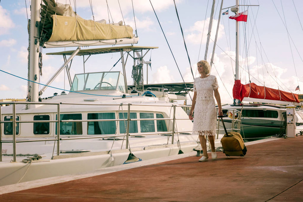 eine ältere Frau in der Nähe einer Jacht, des Meeres, des Urlaubs, des Lebensstils - Foto, Bild