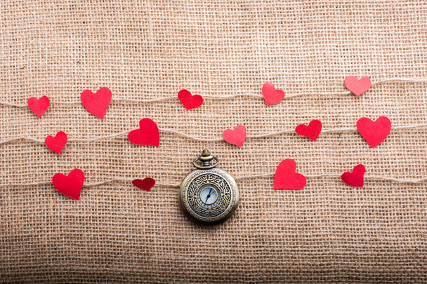 Концепция любви с карманными часами и бумажными сердечками на нитках
 - Фото, изображение