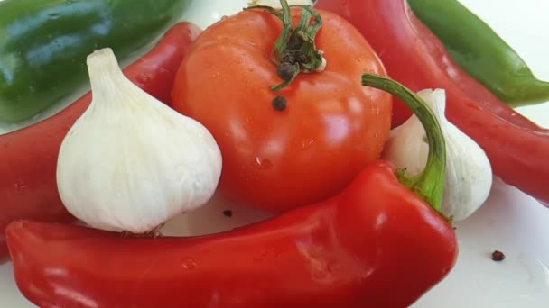 pimiento rojo de tomate, ajo sobre fondo blanco gotas de pimienta negra
 - Metraje, vídeo