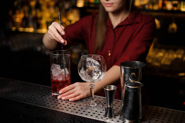 Bartender girl stiring a fresh red cocktail - Foto, Imagen