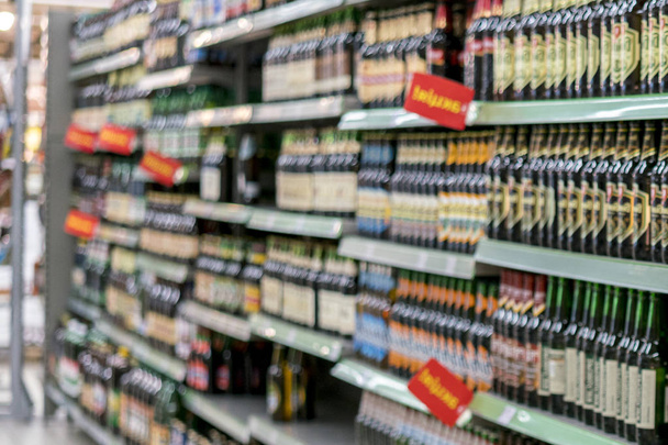 Diferentes tipos de cerveza en los estantes del supermercado. borrosa
 - Foto, imagen