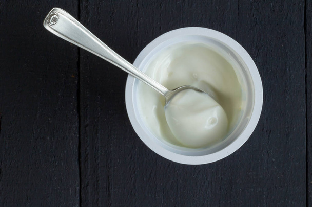 Yogurt cup with natural Greek yoghurt in plastic cup with silver - Фото, зображення