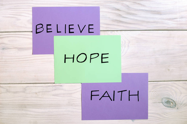 Words believe,hope and faith on wooden table.Image is intentionally toned. - Photo, Image