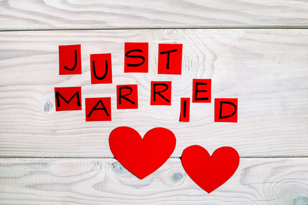 Text just married with heart shapes  on wooden table.Image is intentionally toned. - Photo, Image
