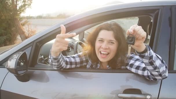 Autofahrerin zeigt Autoschlüssel und lächelt glücklich in ihr neues Auto - Filmmaterial, Video