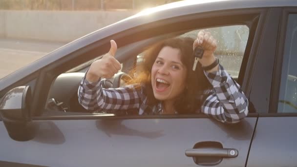 Γυναίκα οδηγός δείχνει τα κλειδιά του αυτοκινήτου χαμογελώντας ευτυχισμένο το νέο αυτοκίνητό της - Πλάνα, βίντεο