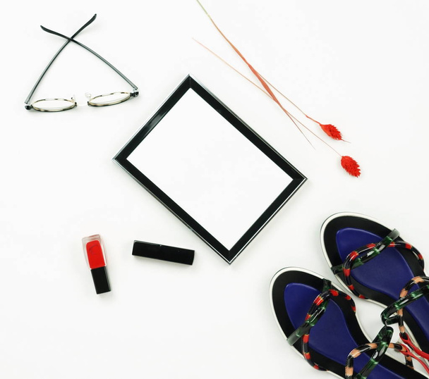 Female fashionable stylish accessories and cosmetics. Female stylish summer sandale shoes,frame,  lipstick ,glasses,  red nail polish on a white background. Beauty blog concept.Flat lay.Top view. Copy space - Foto, Bild