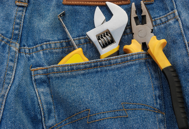 Herramientas en un bolsillo trasero de jean azul
 - Foto, imagen