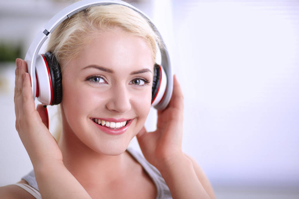 Young beautiful woman at home sitting on sofa and listening music - Foto, Imagen