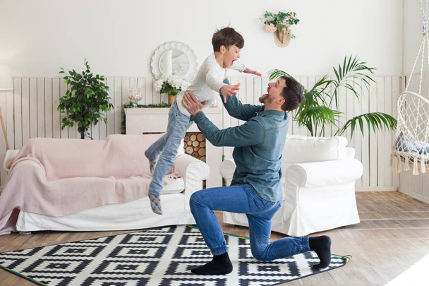 It is always fun to spend your free time with father! Father having a wonderful spare time, while playing with his child and throwing him up at home. - Photo, Image