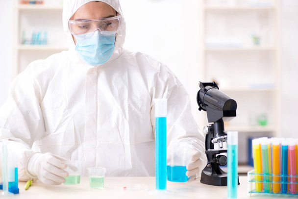 Młody student chemii pracujący w laboratorium nad chemikaliami - Zdjęcie, obraz