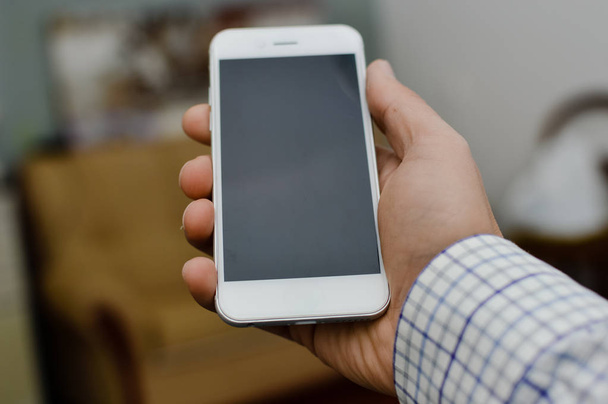 Бізнесмен використовує мобільний телефон на світлому фоні для фото або відео. Написання тексту, перевірка дзвінків, читання повідомлень. Крупним планом зображення пристрою комунікаційних технологій
 - Фото, зображення