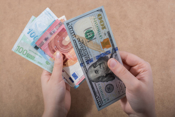 Kézben tartott amerikai dollár bankjegyek elszigetelt fa háttér - Fotó, kép