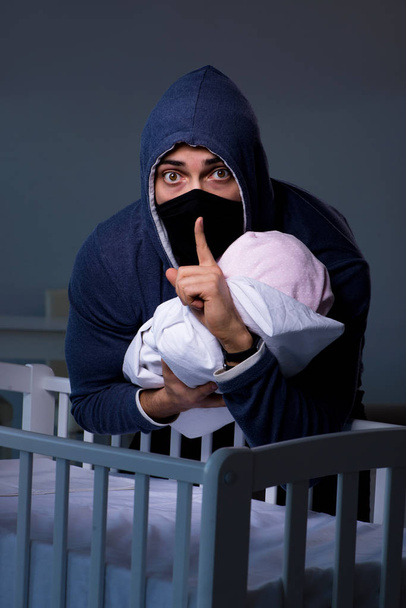 Kriminelle stehlen Baby in menschlichem Kinderaufspürkonzept - Foto, Bild