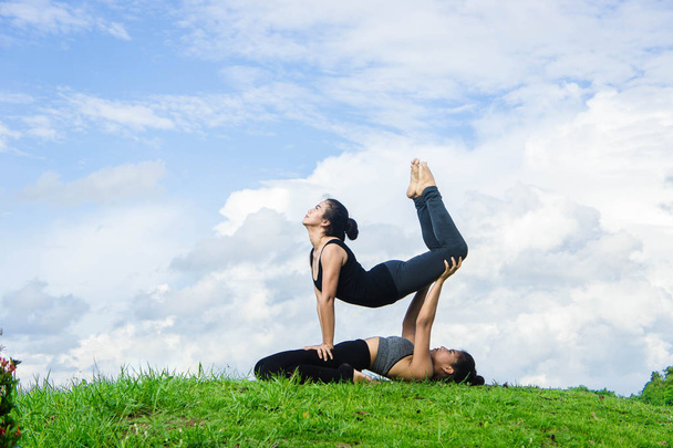 Женщина практикующая йогу расслабиться на природе и голубом фоне неба
 - Фото, изображение