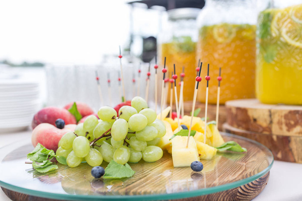 fruit plate. Glass bank of lemonade with sliced citrus fruits on a buffet table. Summer party outdoor. Detox. - Fotografie, Obrázek
