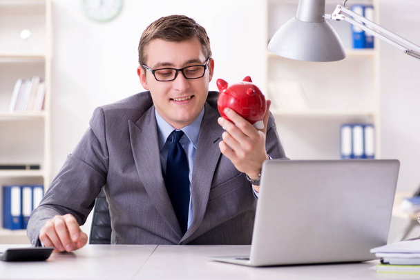 Young employee with piggybank in pension savings concept - Photo, image