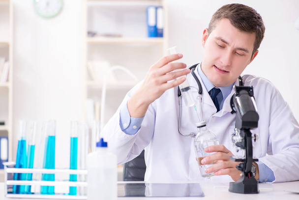 Männlicher Arzt schaut sich Laborergebnisse im Krankenhaus an - Foto, Bild