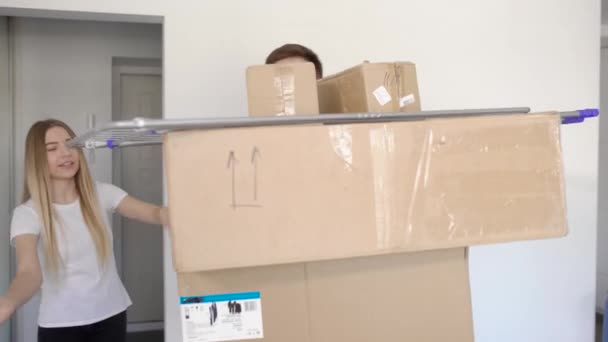Unbekannter Mann steht mit Gepäck in Pappkartons beim Einzug mit Freundin - Filmmaterial, Video