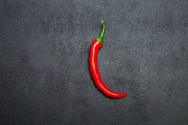 red chili pepper on dark concrete background - 写真・画像