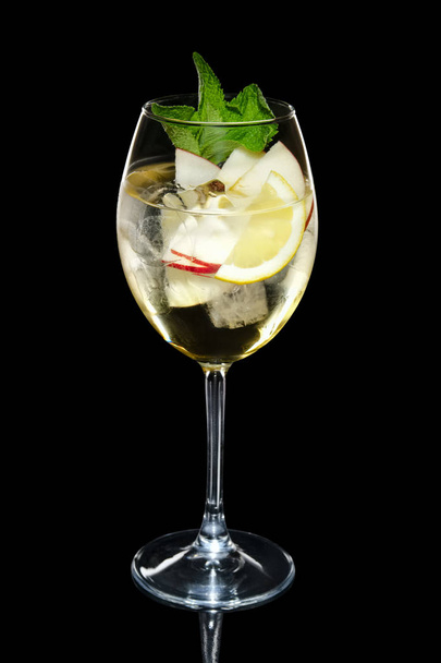 Apple cocktail with a sparkling wine with ice cubes in wine glass isolated on black - Valokuva, kuva