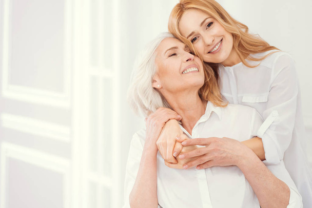 Portrait of loveful mature daughter embracing her elderly mom - Foto, immagini